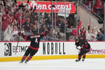 Carolina Hurricanes right wing Seth Jarvis (24) celebrates scoring with defenseman Shayne Gostisbehere (4) in overtime against the Vegas Golden Knights.
