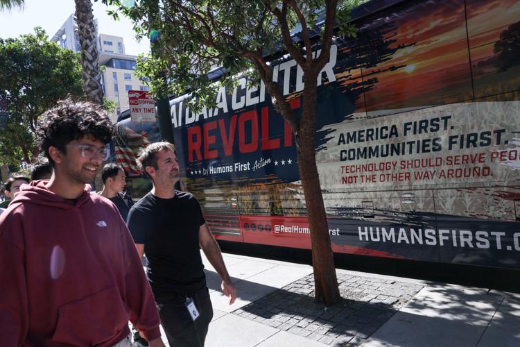 Conservative AI safety group Humans First parks their bus with a message against data centers outside of OpenAI headquarters