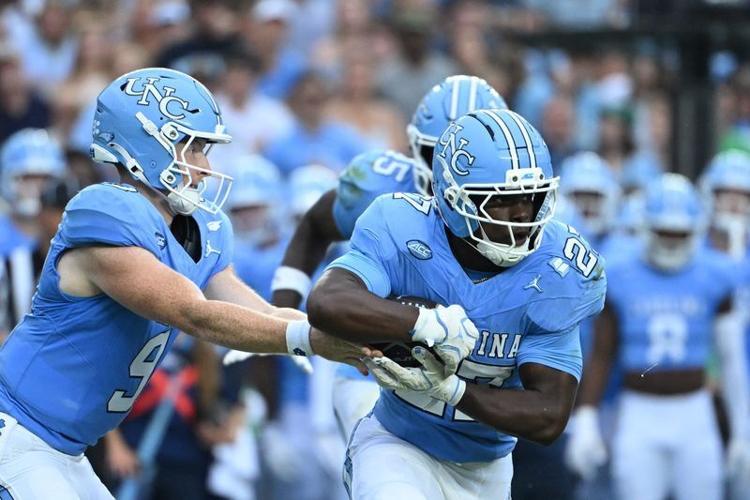 Oct 3, 2026; Chapel Hill, North Carolina, USA;  North Carolina Tar Heels quarterback Billy Edwards Jr. (9) hands the ball off to running back Jaylen McGill (27) in the first quarter at Kenan Stadium. Mandatory Credit: Bob Donnan-Imagn Images