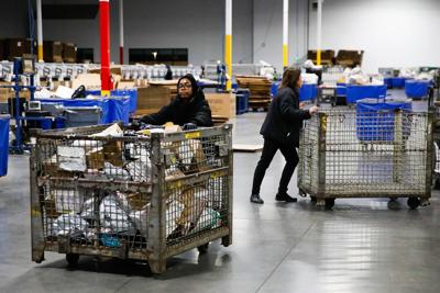 USPS employees sort packages at a distribution center less than two weeks before Christmas on Dec. 13, 2023, in Henderson, Nevada.