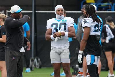 Aug 4, 2026; Charlotte, NC, USA; Backs coach Bernie Parmalee talks with running back Chuba Hubbard (30), running back Jonathon Brooks (25) during training camp at Bank of America Stadium. Mandatory Credit: Jim Dedmon-Imagn Images
