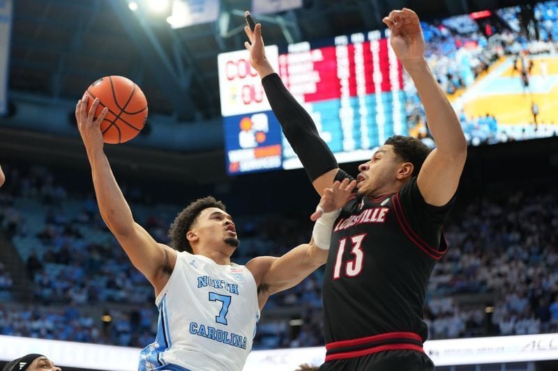 Feb 23, 2026; Chapel Hill, North Carolina, USA; North Carolina Tar Heels guard Seth Trimble (7) shoots as Louisville Cardinals forward Sananda Fru (13) defends in the second half at Dean E. Smith Center. Mandatory Credit: Bob Donnan-Imagn Images