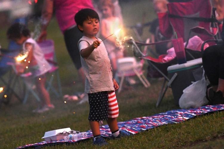 People watch fireworks along the Cape Fear River at the Battleship North Carolina and downtown Wilmington for a night of fireworks in celebration of the 4th of July.
