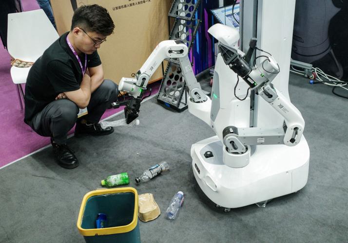 A man looks at the X Square Robot operating at the FAIR Plus robotics supply chain conference, in Shenzhen