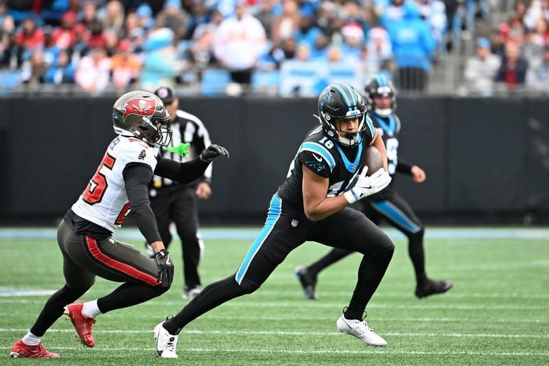 Dec 21, 2025; Charlotte, North Carolina, USA; Carolina Panthers wide receiver Jalen Coker (18) with the ball as Tampa Bay Buccaneers cornerback Jacob Parrish (25) defends in the second quarter at Bank of America Stadium. Mandatory Credit: Bob Donnan-Ima...