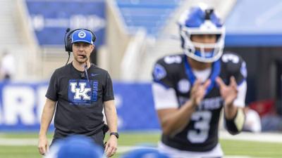 Kentucky head coach Will Stein, background, watched as UK presumptive starting quarterback Kenny Minchey prepared to take the snap during the Wildcats’ Blue-White spring football game.
