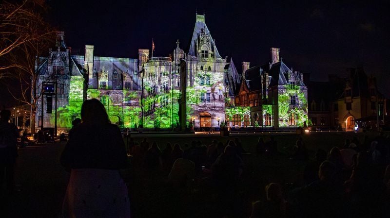 Visitors watch projections on Biltmore House during a media preview of the estate’s Luminere event on March 20, 2026, in Asheville, North Carolina.