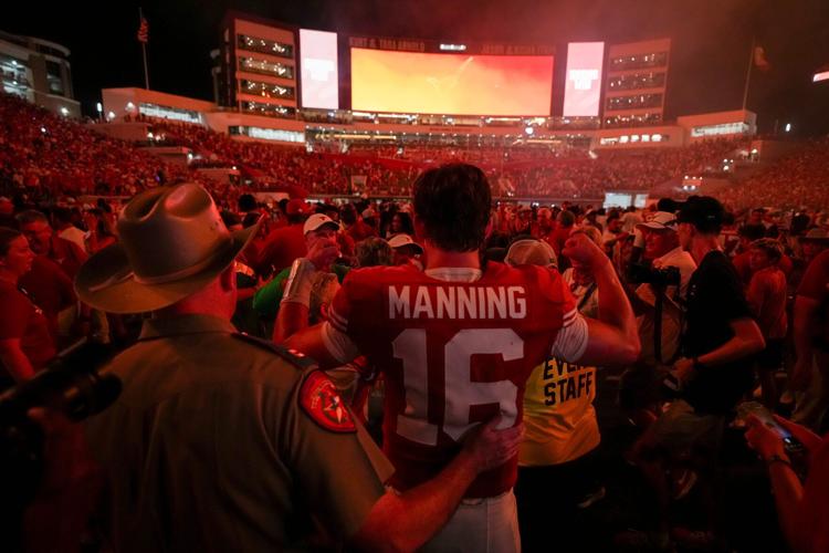 Fans celebrate with Texas quarterback Arch Manning (16) after the team's defeat of Ohio State at Darrell K Royal-Texas Memorial