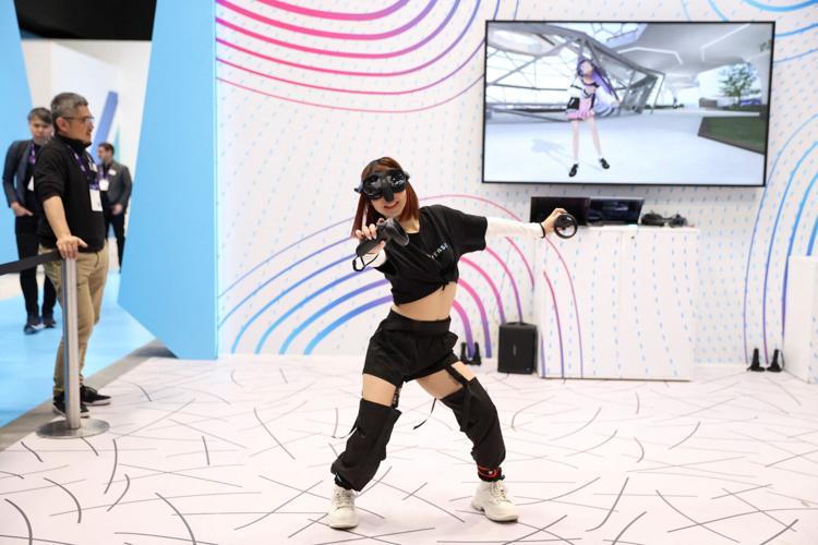A woman plays a video game with virtual reality headset at the Mobile World Congress (MWC), in Barcelona, Spain February 27, 2024.