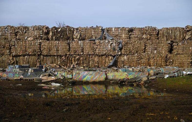 Bales of compressed cardboard and an old foundation of a building decimated by Tropical Storm Helene seen Saturday, Dec. 14, 2024, in the historic River Arts District in Asheville, 11-weeks after Tropical Storm Helene hit Western North Carolina. [Matthe...