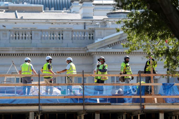 Construction workers stand at the site of the planned White House ballroom.