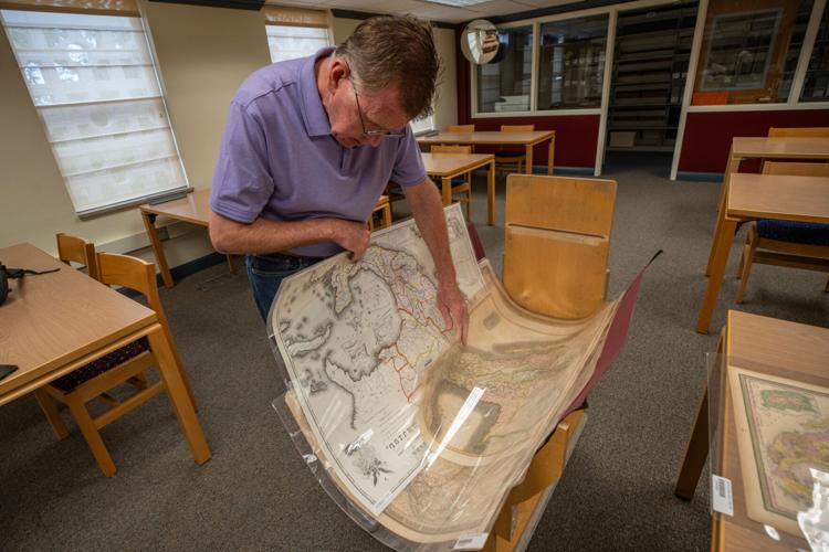 Dennis Daily, an archivist at New Mexico State University, examines historical maps of the U.S.-Mexico border region in the university’s archives. The collection traces shifting national boundaries that reshaped communities in the Paso del Norte area ove