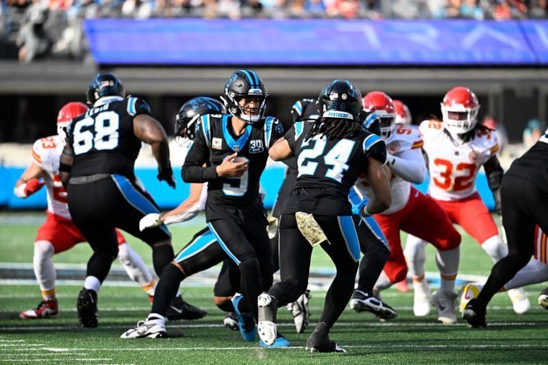 Nov 24, 2024; Charlotte, North Carolina, USA; Carolina Panthers quarterback Bryce Young (9) hands the ball off to running back Jonathon Brooks (24) in the second quarter at Bank of America Stadium. Mandatory Credit: Bob Donnan-Imagn Images