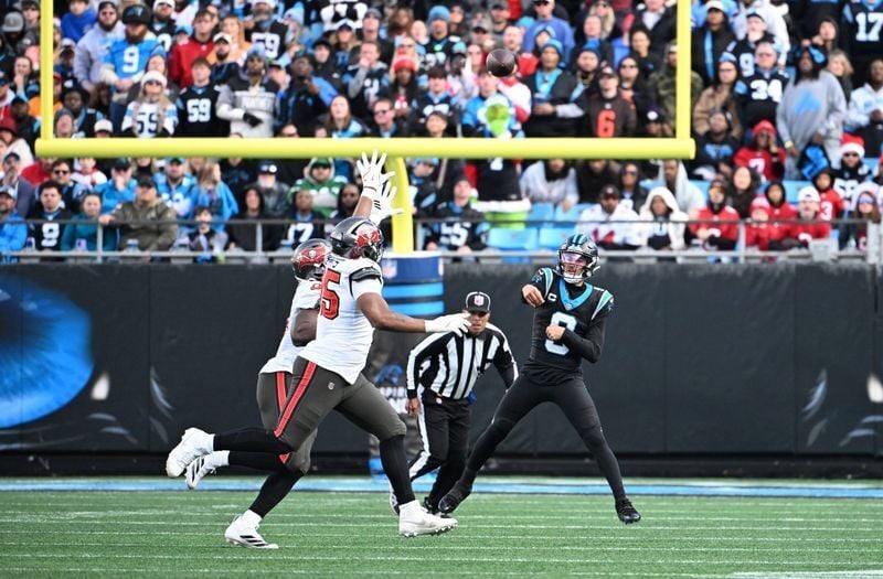 Dec 21, 2025; Charlotte, North Carolina, USA; Carolina Panthers quarterback Bryce Young (9) passes the ball as Tampa Bay Buccaneers linebacker Yaya Diaby (0) and defensive end Elijah Roberts (95) pressure in the fourth quarter at Bank of America Stadium...
