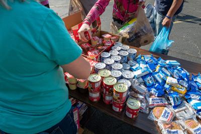 People line up for free food, groceries and clothing at the weekly Saturday River City Street Ministry food distribution on June 10, 2023, in Huntington, West Virginia. The weekly event, which is organized and run by a series of churches including relig...