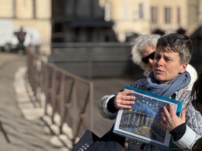 A tour guide shows a picture of Vincent van Gogh's "Starry Night Over the Rhone" in Arles, where the Dutch artist spent a prolific part of his career.