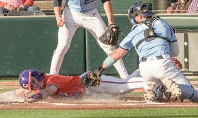 Clemson catcher Nate Savoie (99) is tagged out at home by University of North Carolina junior Macon Winslow (6) during the bottom of the first inning at Doug Kingsmore Stadium in Clemson, S.C. Friday, April 10, 2026.