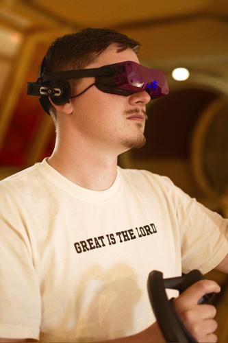 Geoffery Powell of Eureka, Ill., wears his virtual-reality headset as he visits a VR world. Powell, a 28-year-old computer science worker and part-time photographer, started joining members of Christian organization Cru for virtual-reality ministry outreac
