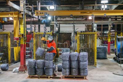 A Liberty Steel worker loads a pallet with newly rolled barbed-wire Tuesday, Sept. 23, 2025 at the factory in Bartonville.