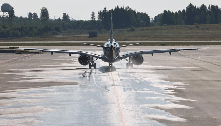 A plane drives on the wet runway at the airport in Oslo