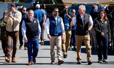 From left, Dave Natonski, chief of staff for U.S. Homeland Security Secretary Markwayne Mullin; U.S. Rep. Tim Moore; Mullin; Chimney Rock Mayor Peter O’Leary; and FEMA Administrator Karen Evans walk across a bridge in Chimney Rock on April 7, 2026, duri...