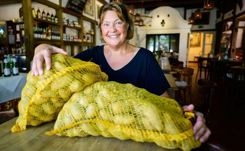 Sylvia Methfessel who works at Germany's first hotel dedicated to the potato. Here, with two sacks of spuds.