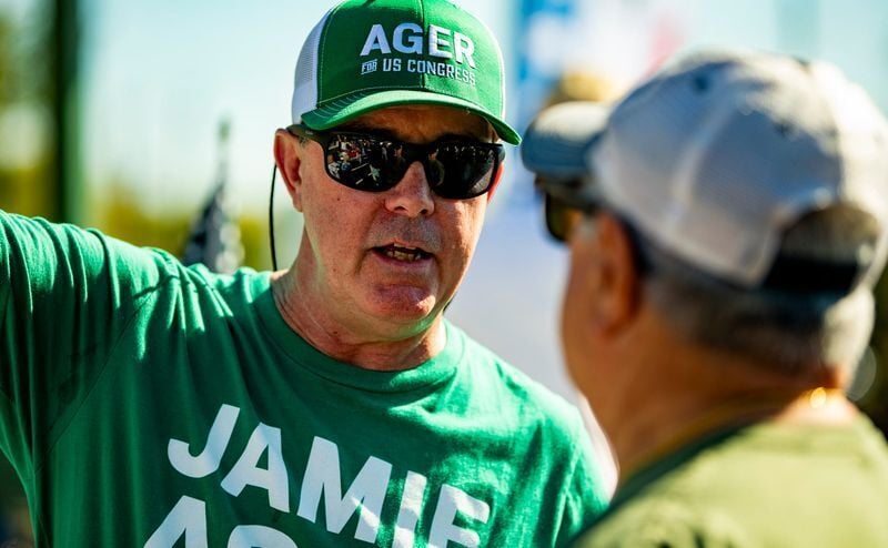A campaign supporter wearing a Jamie Ager for U.S. Congress shirt talks with another person outside the Henderson County Board of Elections during early voting in Hendersonville on Oct. 15, 2026.