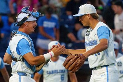 Jun 14, 2026; Omaha, NE, USA; North Carolina Tar Heels pitcher Caden Glauber (27) and North Carolina Tar Heels catcher Colin Hynek (23) embrace after defeating the West Virginia Mountaineers at Charles Schwab Field. Mandatory Credit: Dylan Widger-Imagn ...