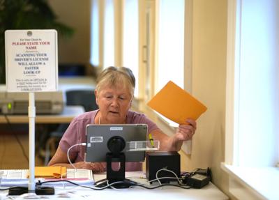 Dennis Precinct 2 clerk Jacqui Mulolland processes mail-in ballots at the Dennis Senior Center in South Dennis Tuesday morning.