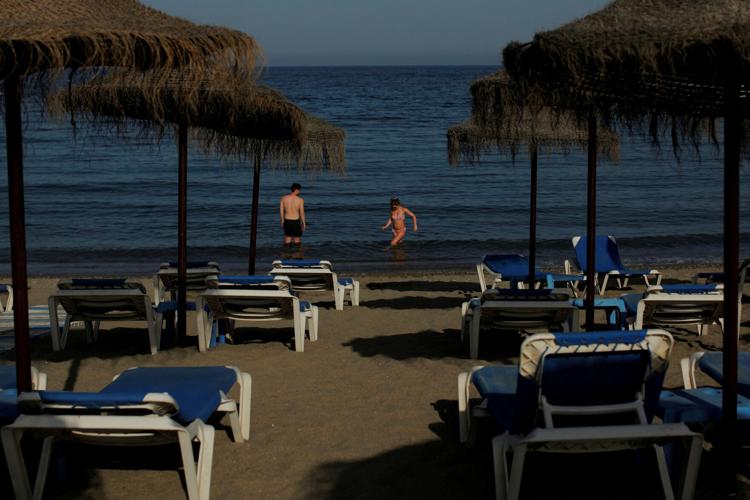 FILE PHOTO: A couple cools off at the Mediterranean Sea during a hot spring day on Nueva Andalucia beach in Marbella