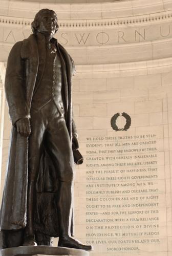 Interior of Jefferson Memorial in Washington DC with Jefferson on the left and an inscription from the Declaration of Independence on the right.