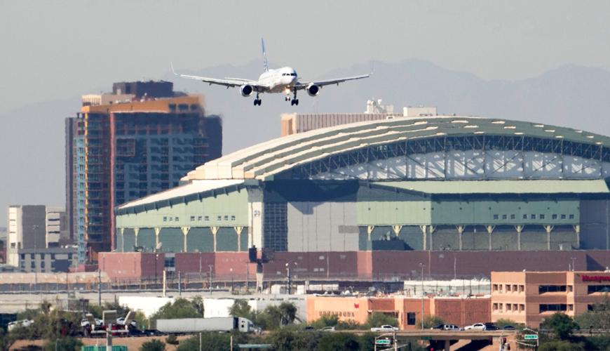 United Airlines flight 1796 flies past Chase Field on approach to Phoenix Sky Harbor International Airport on Nov. 7, 2025, during the government shutdown.