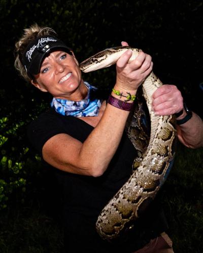Amy Siewe holds an invasive 10-foot Burmese Python on Sept. 5, 2024, in Miami.