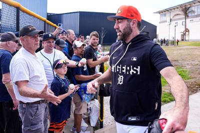 Detroit Tigers pitcher Justin Verlander waves at fans as he runs toward the field for practice during spring training at