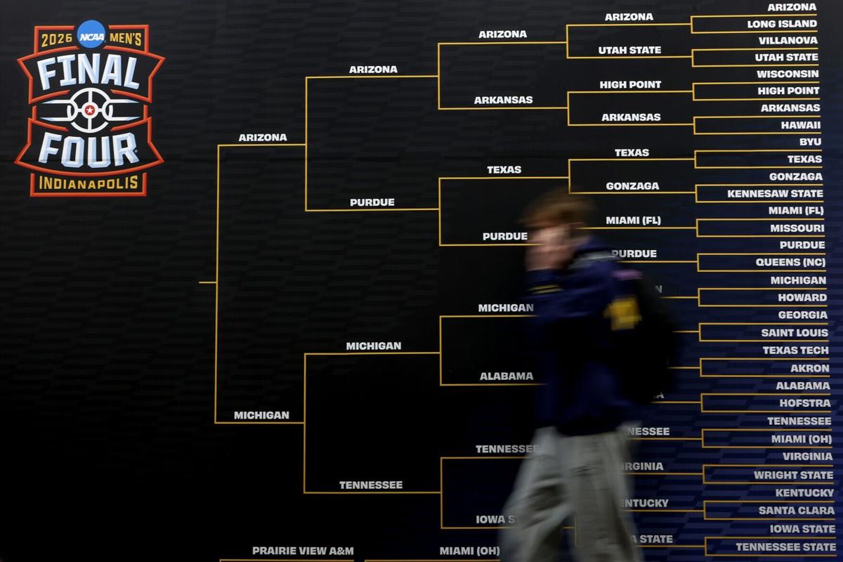 A person walks past a large bracket during the practice day of the 2026 NCAA Men's Basketball Tournament at Lucas Oil Stadium on April 3, 2026, in Indianapolis.