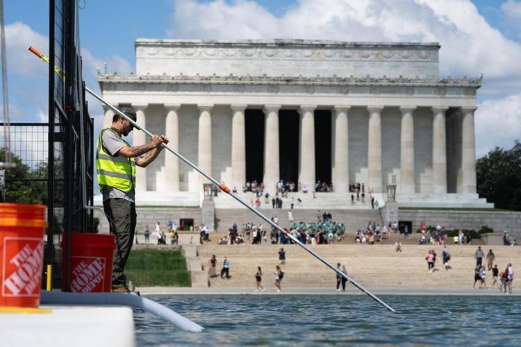 Crews clean up algae that began to grow in the Reflecting Pool days after the Trump administration's at least $13 million renovation project that repainted the surface.