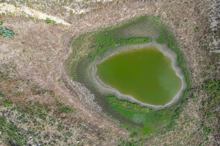 A drained lake bed sits on the property of an abandoned marijuana grow in rural Holdenville.