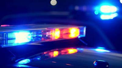 Emergency lights flashing on police cars at night at the scene of an accident or crime. Focus shifts from lights in the foreground to the lights in the background.