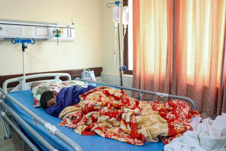 An injured victim lies in a hospital bed, following a reported attack near a wedding, near Sirik