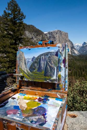 A man paints the scene from the tunnel view.