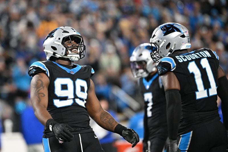 Jan 10, 2026; Charlotte, NC, USA; Carolina Panthers defensive tackle Tershawn Wharton (99) reacts with linebacker Nic Scourton (11) in the third quarter in an NFC Wild Card Round game at Bank of America Stadium. Mandatory Credit: Bob Donnan-Imagn Images