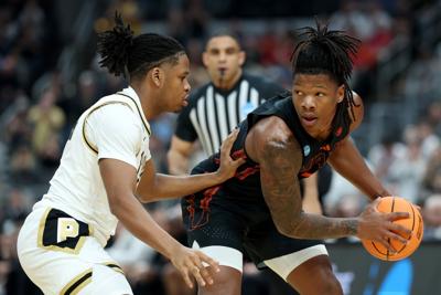 Shelton Henderson of the Miami Hurricanes dribbles against Gicarri Harris of the Purdue Boilermakers during the first half in the second round of the 2026 NCAA Men's Basketball Tournament at Enterprise Center on Sunday, March 22, 2026, in St Louis.