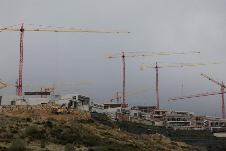FILE PHOTO: Cranes are seen over houses under construction of La Finca de Jasmine, in Benahavis