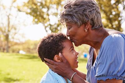 Close Up Of Grandmother Kissing Grandson In Park