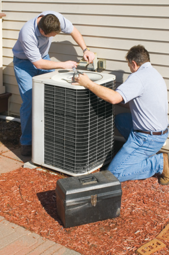 HVAC technicians servicing an outdoor air conditioning unit.