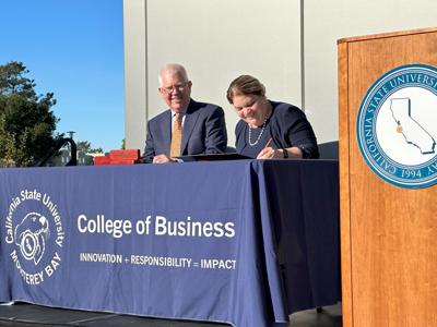 Pebble Beach Company David Stivers, left, watches as CSU Monterey Bay President Vanya Quiñones signs an agreement (copy)