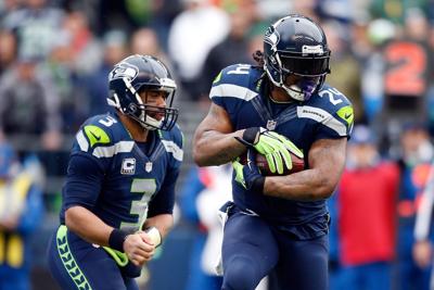 Seattle Seahawks quarterback Russell Wilson hands the ball off to running back Marshawn Lynch against the Green Bay Packers during the NFC Championship game on Jan. 18, 2015, in Seattle.