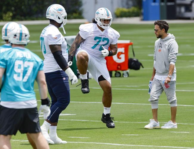 Miami Dolphins offensive lineman Jonah Savaiinaea runs through drills as coach Mike McDaniel watches during Dolphins rookie minicamp at the Baptist Health Training Complex in Miami Gardens, Florida on Friday, May 9, 2025.