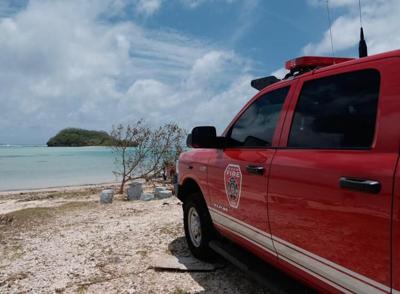 Guam Fire Department rescue vehicles are situated beside Hotel Santa Fe Guam during a search for a missing swimmer in Tamuning on Friday.