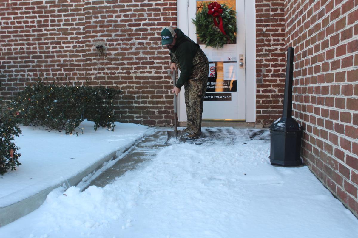 Billy Thompkins shovels snow off the sidewalks of Conway City Hall Thursday morning